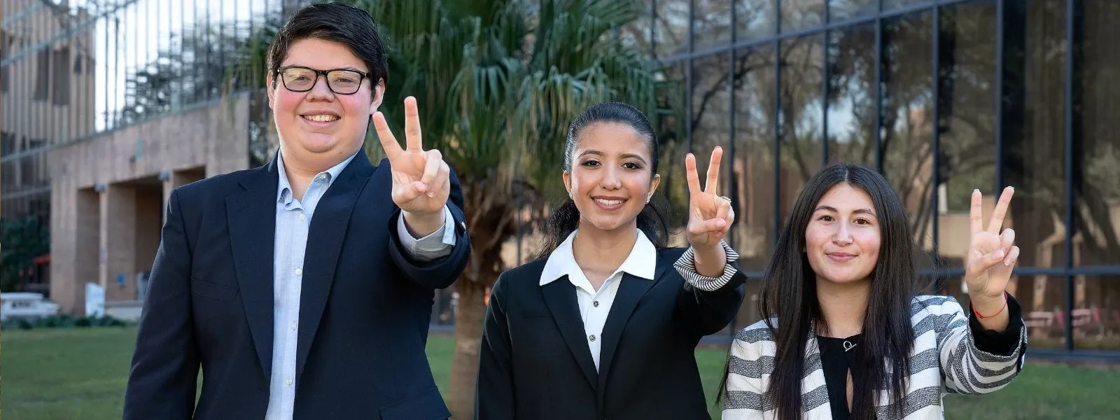 Students give V's up hand sign and smile